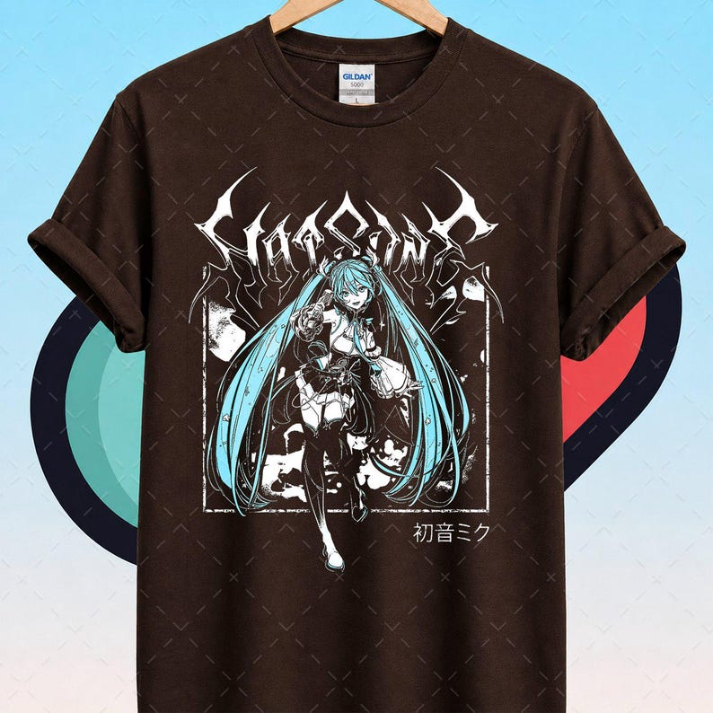 May include: Brown t-shirt featuring a graphic of a female anime character with long, turquoise hair. The design includes the text "Hatsune Miku" in stylized lettering and Japanese characters. The character is set within a white rectangular frame.