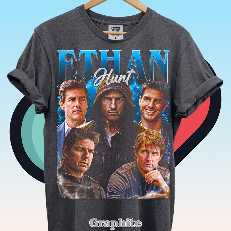Może przedstawiać: Ciemnoszary t-shirt z kr&oacute;tkim rękawem z nadrukiem graficznym przedstawiającym Ethana Hunta. Wz&oacute;r zawiera pięć r&oacute;żnych wizerunk&oacute;w postaci, napis "ETHAN" dużymi niebieskimi literami, napis "Hunt" oraz błyskawice na ciemnym tle.