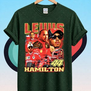 Pode incluir: T-shirt verde escuro com um gr&aacute;fico de Lewis Hamilton em fato e capacete de corrida vermelhos. Os textos "LEWIS" e "HAMILTON" s&atilde;o em amarelo e vermelho. O n&uacute;mero "44" &eacute; exibido de forma proeminente.