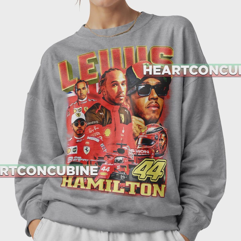 Pode incluir: Camisola cinzenta com um design gr&aacute;fico em estilo vintage de Lewis Hamilton. O design inclui v&aacute;rias imagens de Hamilton, um carro de corrida vermelho e o texto "LEWIS HAMILTON 44". A camisola tem gola redonda e mangas compridas.