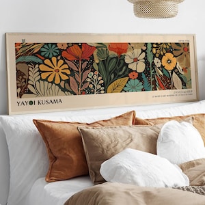 Könnte beinhalten: Ein gerahmter Kunstdruck mit einem farbenfrohen Blumenmuster. Das Kunstwerk zeigt Blumen in Orange-, Gelb- und Blautönen. Der Druck enthält den Text "YAYOI KUSAMA" und japanischen Text.
