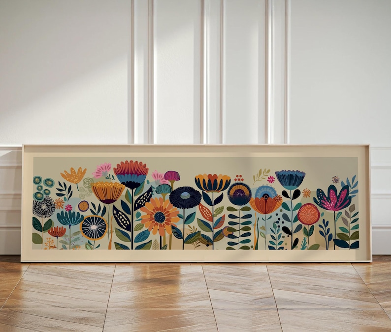 May include: A framed floral art print featuring a colorful array of stylized flowers in shades of orange, blue, pink, and yellow. The artwork is set against a light beige background and framed in a light wood tone.