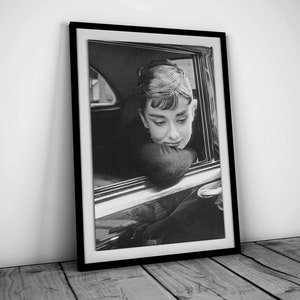 May include: Black and white photograph of a woman looking out of a car window. She is wearing a dark sweater and has her hair pulled back.