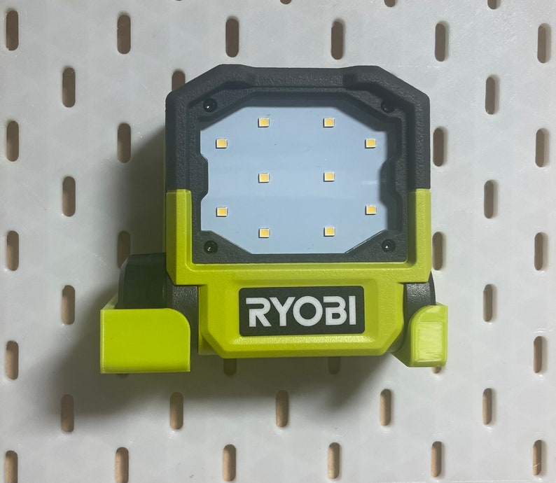 以下が含まれることがあります： 前面に「RYOBI」と書かれた緑と黒の作業灯。ライトは12個のLED電球と旋回ヘッドを搭載しています。