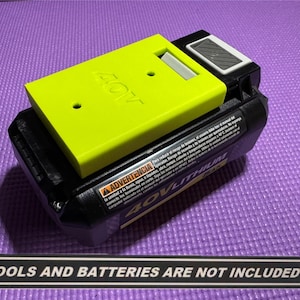 May include: A black and yellow 40V Lithium battery with a lime green adapter. The adapter has the number "40V" printed on it. The text "TOOLS AND BATTERIES ARE NOT INCLUDED" is at the bottom.