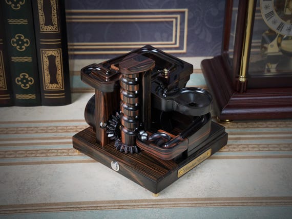 A handcrafted ebony wood spiral marble machine module — mesmerizing kinetic desk art where a real craftsperson engineered every groove and channel.