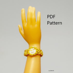 May include: A gold crochet watch with a white face. The watch is on a doll's wrist. PDF Pattern.