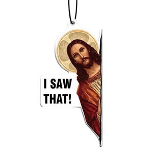 May include: A white car air freshener with a picture of Jesus peeking out from behind a speech bubble that says "I saw that!"