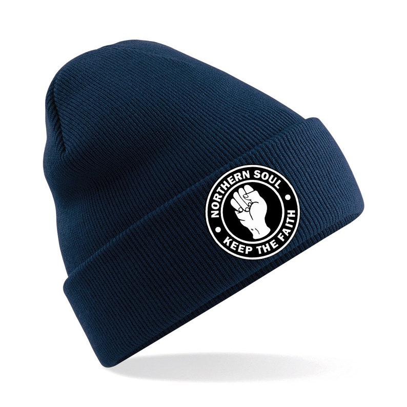 May include: A navy blue beanie with a white circle logo that says "Northern Soul Keep The Faith" with a raised fist in the center.