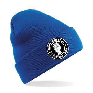 May include: A royal blue beanie with a white circle patch that says "Northern Soul Keep The Faith" with a raised fist in the center.