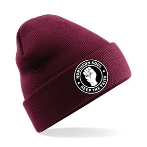 May include: A maroon beanie with a white circle logo that says "Northern Soul Keep The Faith" with a raised fist in the center.