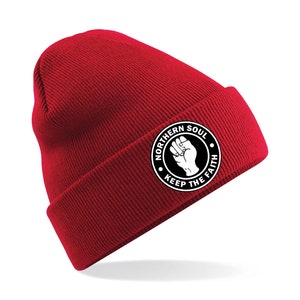 May include: Red knit beanie with a white circle logo that says "Northern Soul Keep The Faith" with a raised fist inside the circle.