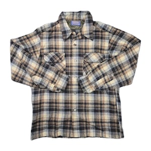 May include: A button-down plaid shirt in shades of brown, black, and cream. The shirt has two chest pockets, a collar, and buttoned cuffs. The fabric appears to be a medium-weight material.