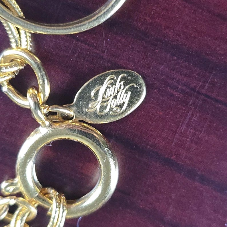 Pulsera con dije "El secreto de los siete ángeles" de Kirks Folly, estilo vintage, en caja. imagen 2