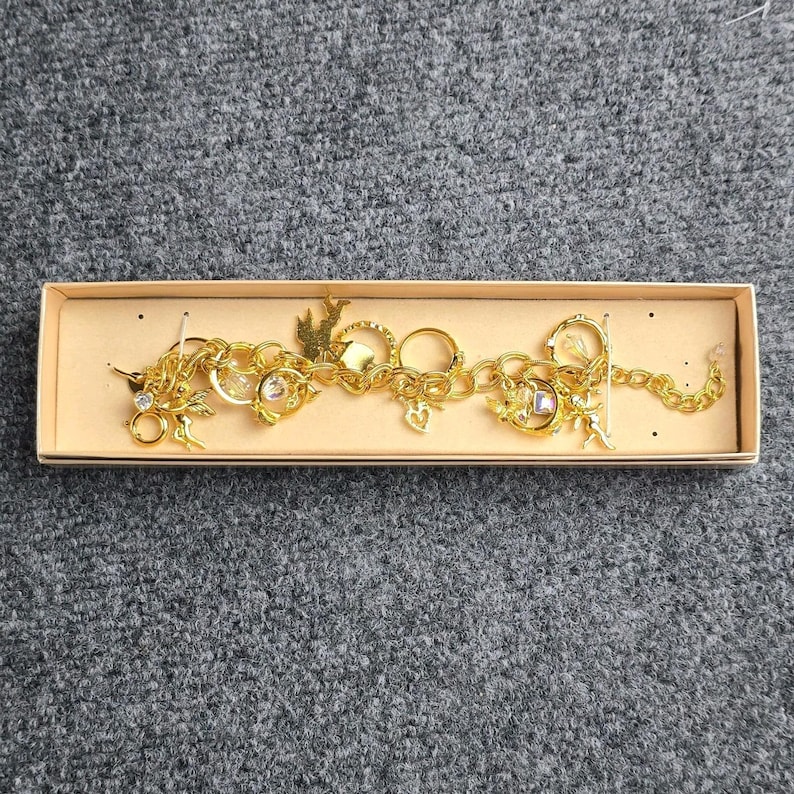 Pulsera con dije "El secreto de los siete ángeles" de Kirks Folly, estilo vintage, en caja. imagen 9