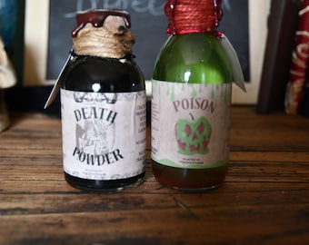 May include: Two decorative glass bottles with labels reading "DEATH POWDER" and "POISON". The bottles have decorative stoppers and are on a wooden surface. The "POISON" bottle has a green apple graphic.