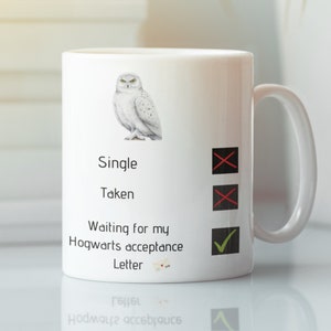 以下が含まれることがあります： 雪のフクロウのイラストが描かれた白いセラミックマグカップ。マグカップには、「シングル」、「既婚」、「ホグワーツ入学許可証が届くのを待っています」というテキストが書かれており、各オプションの横にチェックボックスがあります。「ホグワーツ入学許可証が届くのを待っています」の横にあるチェックボックスがチェックされています。