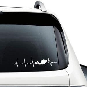 Op de afbeelding: Witte vinyl sticker met een silhouet van een duiker met een hartslaglijn. De sticker zit op de achterruit van een witte auto.