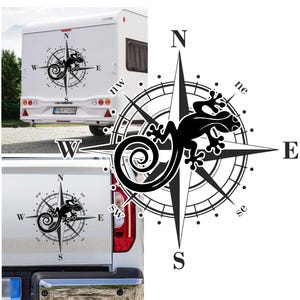Può includere: Bussola in bianco e nero con un design a forma di geco. La bussola indica le direzioni nord, sud, est e ovest. Il geco è rivolto a est. La bussola è su uno sfondo bianco.