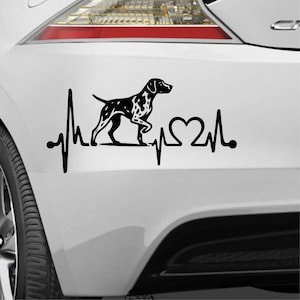 Könnte beinhalten: Schwarz-weißer Aufkleber eines Hundes, möglicherweise eines Dalmatiners, mit einer Herzschlaglinie und einer Herzform. Der Aufkleber ist auf der weißen Oberfläche eines Fahrzeugs in der Nähe des Rücklichts angebracht.