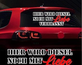 Pode incluir: Um carro vermelho com um adesivo preto e branco na janela traseira que diz "HIER WIRD DIESEL NOCH MIT Liebe VERBRANNT". A palavra "Liebe" está em vermelho.