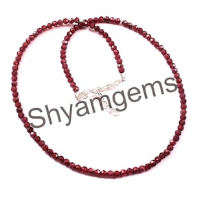 May include: A red garnet gemstone necklace with a silver clasp. The necklace is made of small, faceted beads and is approximately 18 inches long.