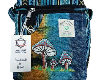 May include: A colorful hemp crossbody bag with a mushroom design. The bag features a zipper closure, a tag that says "Ancient Wisdom Handmade in Nepal", and a "Himalayan Hemp" label. The bag is made of blue, green, and orange fabric.