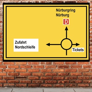 Puede incluir: Un letrero vial amarillo con bordes negros y texto, montado en una pared de ladrillos. El letrero indica las direcciones a Nürburgring y Nürburg, con un gráfico de rotonda y la palabra "Tickets".