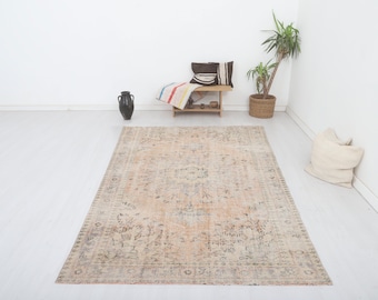 Può includere: Un tappeto vintage con un motivo floreale sbiadito in tonalità beige, rosa e blu. Il tappeto ha un aspetto vissuto ed è perfetto per aggiungere un tocco di stile bohémien a qualsiasi ambiente.
