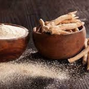 Puede incluir: Dos cuencos de madera, uno lleno de un polvo marr&oacute;n claro y el otro con trozos secos, marr&oacute;n claro, en forma de ramitas. Ambos cuencos est&aacute;n sobre una superficie de madera marr&oacute;n oscura.