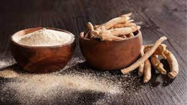 Puede incluir: Dos cuencos de madera, uno lleno de un polvo marr&oacute;n claro y el otro con trozos secos, marr&oacute;n claro, en forma de ramitas. Ambos cuencos est&aacute;n sobre una superficie de madera marr&oacute;n oscura.