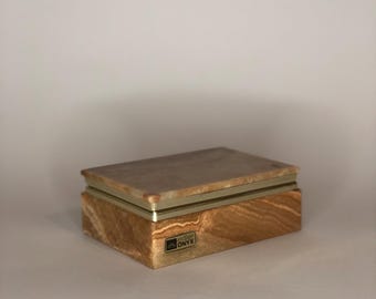 Puede incluir: Una caja rectangular de ónix marrón y beige con un borde dorado. La caja tiene una tapa con bisagras y una etiqueta que dice "Italian Onyx".