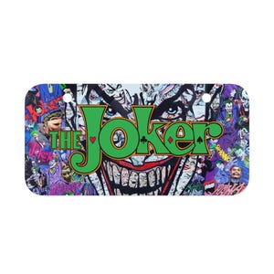 Könnte beinhalten: Rechteckiges Nummernschild mit einer Collage von Joker-Bildern. Das grinsende Gesicht des Jokers steht im Mittelpunkt, mit grünem und orangefarbenem Text "THE JOKER". Der Hintergrund ist ein chaotischer Mix aus Joker-Illustrationen in verschiedenen Posen und Farben, darunter Lila, Grün und Weiß.