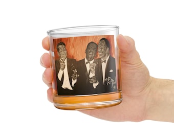 Puede incluir: Un vaso de vidrio transparente con una imagen impresa de tres hombres en blanco y negro. La imagen es del Rat Pack, un grupo de artistas de la década de 1960. La imagen está rodeada por un borde marrón.