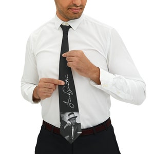 May include: Black silk tie with a black and white photo of Frank Sinatra and his signature in white.