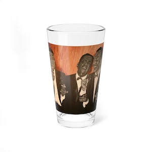May include: A clear glass pint glass with a printed image of three men in suits singing. The background is a blurred orange and yellow color.