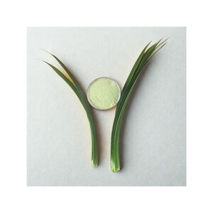Peut inclure: Une composition minimaliste avec un petit r&eacute;cipient rond et transparent rempli d'une poudre vert clair, plac&eacute; entre deux brins d'herbe verts et jaunes. L'ensemble est pos&eacute; sur un fond uni blanc cass&eacute;, cr&eacute;ant une esth&eacute;tique naturelle et spa.