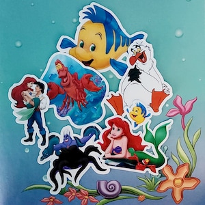 May include: A colourful illustration featuring characters from the Disney film The Little Mermaid. The characters include Ariel, Ursula, Sebastian, Flounder, and Scuttle. The illustration is perfect for fans of the film and would make a great addition to any Disney collection.