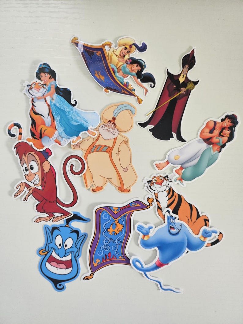 May include: A collection of colorful die-cut stickers featuring characters and elements from the animated film Aladdin. The stickers include Aladdin, Jasmine, Genie, Abu, Jafar, and a magic carpet.