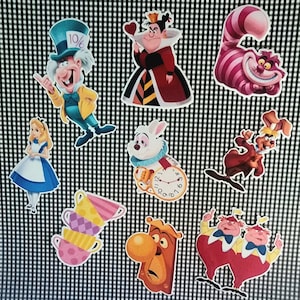 Könnte beinhalten: Ein Set mit 10 Ausschnitten von Alice-im-Wunderland-Charakteren. Die Charaktere umfassen Alice, den Hutmacher, die Herzkönigin, die Grinsekatze, das weiße Kaninchen, den Märzhasen, das Murmeltier, die Zwillinge Tweedledee und Tweedledum sowie die sprechende Tür. Die Ausschnitte sind auf weißem Karton gedruckt und eignen sich perfekt zum Dekorieren einer Party oder eines Klassenzimmers.