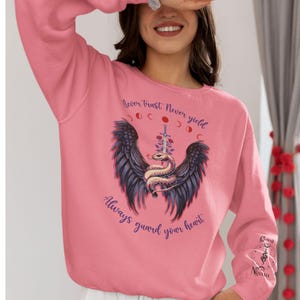 Always Guard Your Heart Crowns of Nyaxia met sweater met mouwembleem, wijze woorden voor de kleine slang, Oraya, van Carissa Broadbent