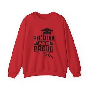 Puede incluir: Una sudadera roja con el texto negro "PH. DIVA AND PROUD". El diseño incluye un gorro de graduación y elementos decorativos. La sudadera es una prenda de manga larga.