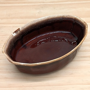 Peut inclure: Plat à four ovale en céramique marron avec une finition brillante. Le plat a un intérieur brun foncé et un bord brun clair. Le plat est vide et prêt à l'emploi.