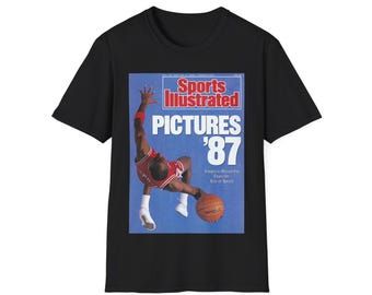 Könnte beinhalten: Schwarzes T-Shirt mit einem Vintage-Cover des Sports Illustrated Magazins, auf dem Michael Jordan beim Basketballspielen zu sehen ist. Das Cover trägt die Aufschrift "Pictures '87" und "Images to Remember From the Year in Sports".