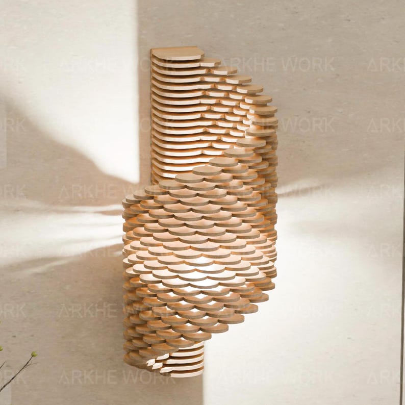 Puede incluir: Una l&aacute;mpara de pared de madera con un dise&ntilde;o en espiral. La l&aacute;mpara est&aacute; hecha de muchas piezas peque&ntilde;as de madera superpuestas, creando un patr&oacute;n &uacute;nico e intrincado. La luz brilla a trav&eacute;s de la madera, creando un brillo c&aacute;lido y acogedor.