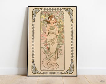 May include: A vintage art nouveau poster featuring a woman in a flowing white dress surrounded by pink and yellow flowers. The poster is framed in a black frame with a gold and white decorative border.