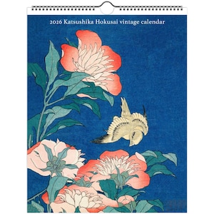May include: 2026 Katsushika Hokusai vintage calendar with a Japanese woodblock print. The print shows a bird in flight above large, pink and white peonies with green leaves against a deep blue background. The calendar is spiral-bound.