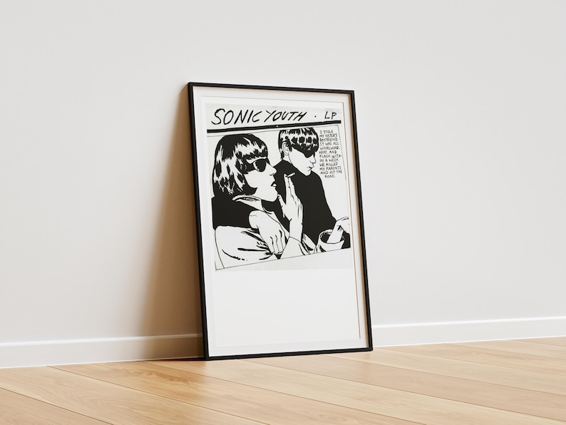 Puede incluir: Impresi&oacute;n enmarcada en blanco y negro con una ilustraci&oacute;n de estilo pop art de dos personas con gafas de sol. La impresi&oacute;n tiene el texto "SONIC YOUTH - LP" en la parte superior. La imagen est&aacute; apoyada contra una pared blanca sobre un suelo de madera.