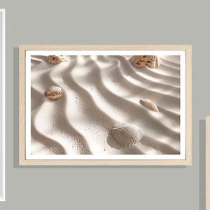 Könnte beinhalten: Gerahmter Druck mit einer sandigen Strandszene mit mehreren Muscheln, die über den geriffelten Sand verstreut sind. Die Muscheln variieren in Größe und Form, mit einer Mischung aus Beige- und Brauntönen. Der Druck ist in einem hellen Holzrahmen.