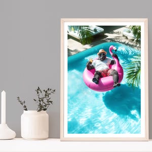May include: A framed print showing a gorilla in a swimming pool, floating on a pink flamingo. The gorilla wears a hat, sunglasses, and red shorts, holding a drink. The pool has clear blue water, with palm trees in the background.